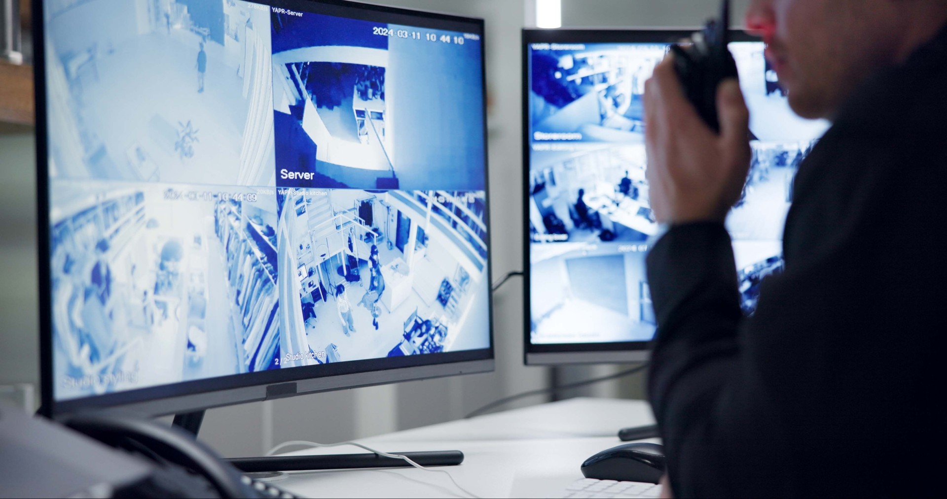 Male security guard, radio and speaking by cctv monitor for protection, data center or building safety. Inspection, control room with man and footage in video surveillance agency, computer and watch